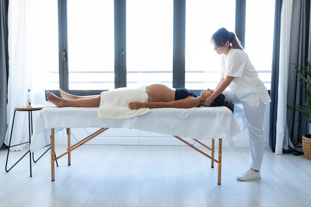 a pregnant woman receiving chiropractic care lying down