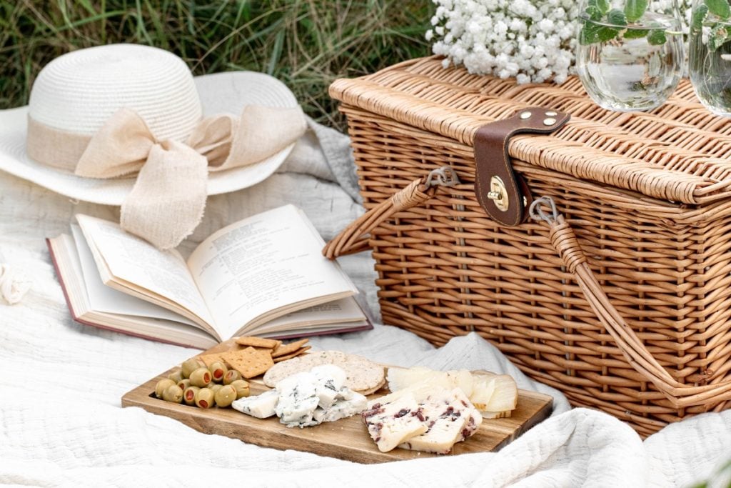 a picnic basket on a blanket with food