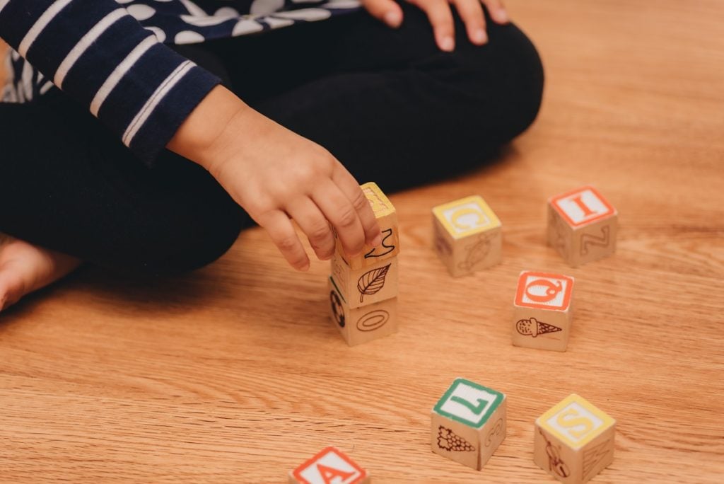 child playing blocks on hardwood floor