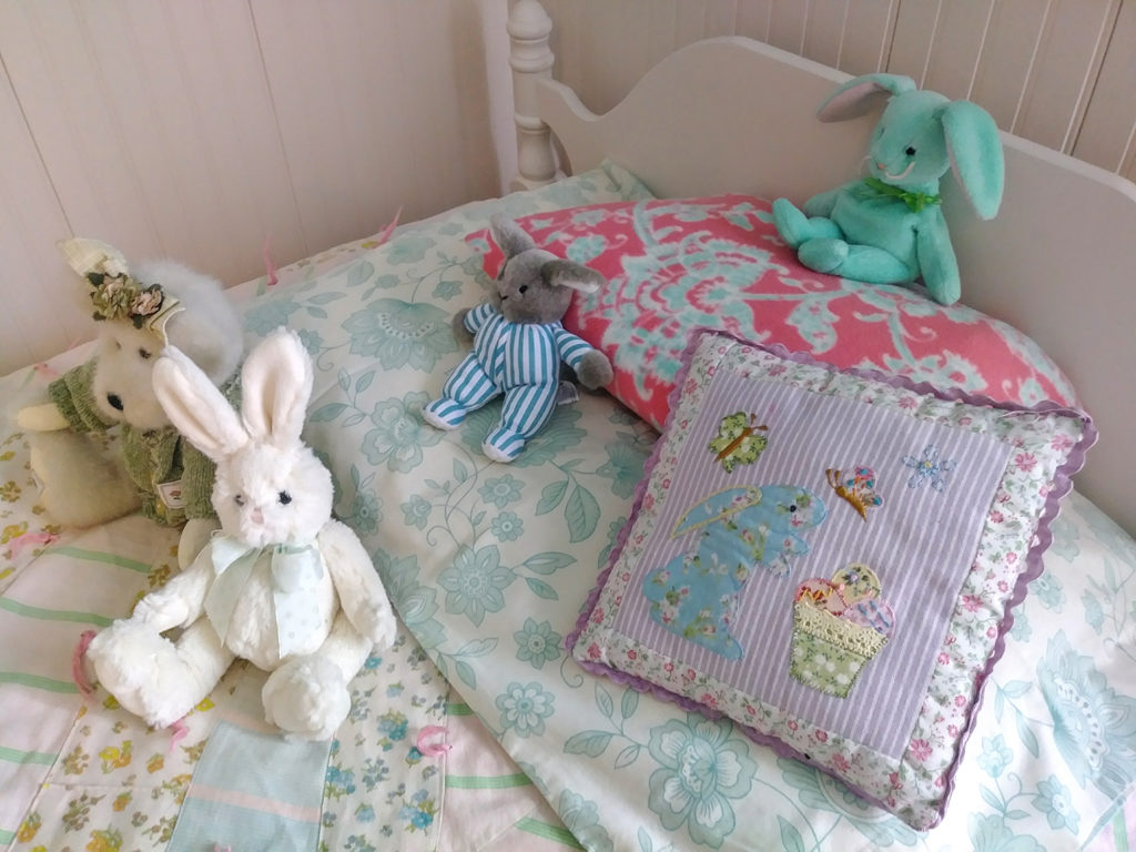 Children's bed with quilt and stuffed animals