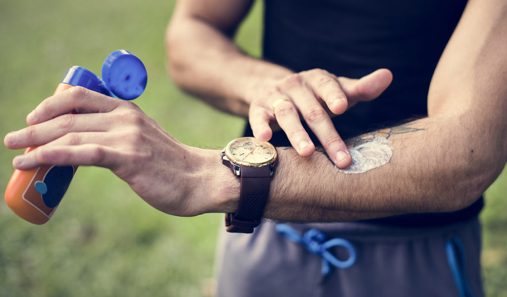 Person applying sunscreen to their arm