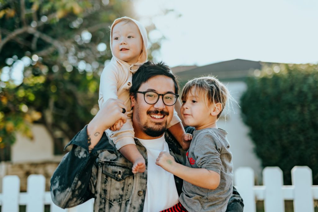 a father holding two young children